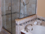 A bathroom with custom tile, and a custom shower door.