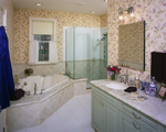 A bathroom with a corner tub and a glass custom shower door.