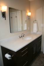 A remodeled bathroom done with Brookhaven cabinetry and custom tile design.