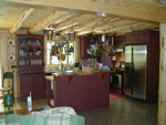 A red painted kitchen with stainless steal appliances.