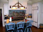 A custom kitchen with white parimeter cabinets and a cottage blue island.