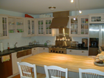 A custom white kitchen with stainless steel appliances.