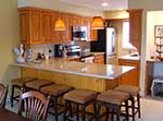 A rustic looking kitchen with framed doors and a light stain.