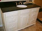 A bathroom with a white vanity and a black vanity top.