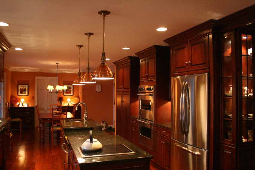 A cherry kitchen with raised panels and stainless steel appliances.