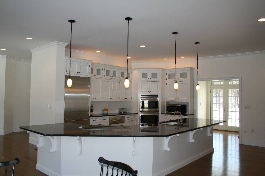 A Contemporary white wood-mode kitchen with sub-zero appliances, and absolute black granite countertops
