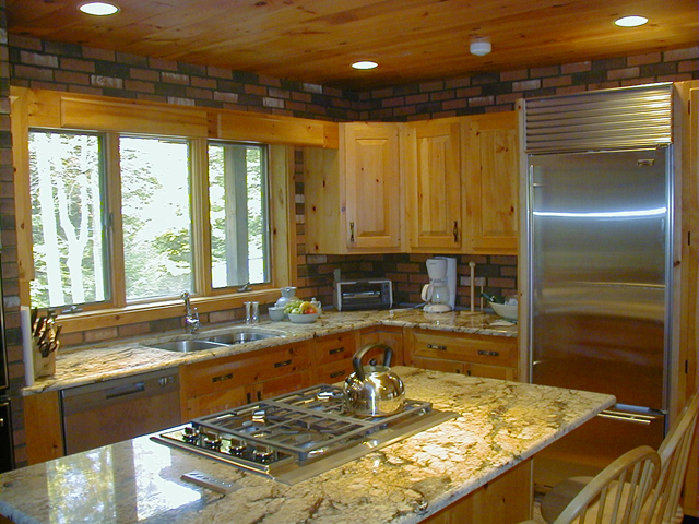 A rustic kitchen with a sub-zero refrigerator and a wolf cooktop.