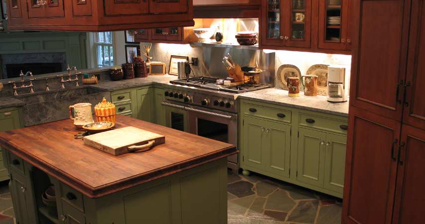 A Custom green painted Wood-mode kitchen with a wolf dual fuel range