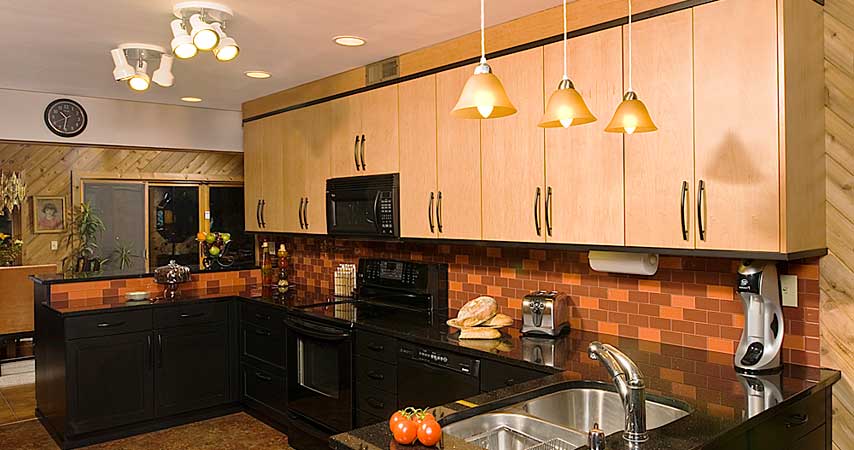 A contemporary maple Wood-mode kitchen with a black granite counter-top.