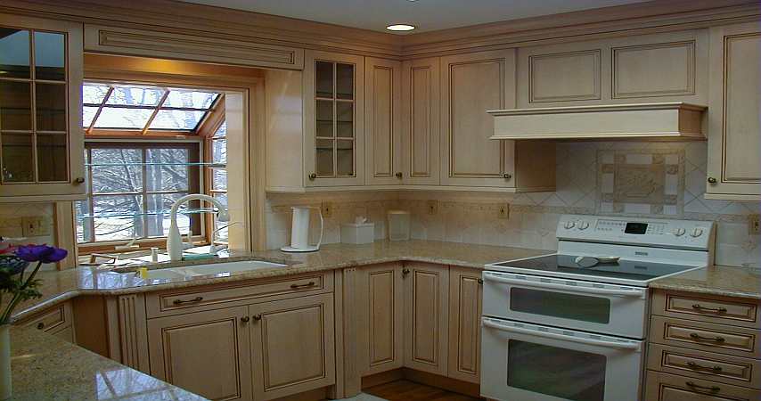 A Maple Wood-mode kitchen with a gold colored granite countertop.
