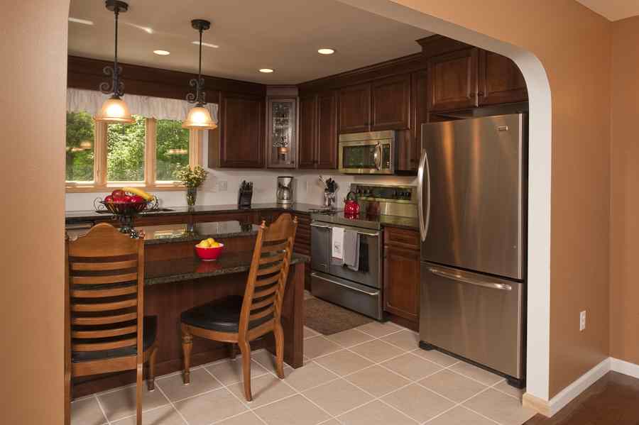 A semi-custom medallion kitchen with a dark stain and raised panels.