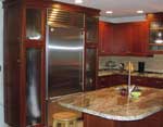 A dark stained cherry kitchen with a sub-zero refrigerator.