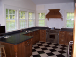 A cherry custom woodmode kitchen with a wood hood and a wolf range.