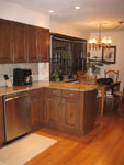 A dark cherry kitchen with granite counter-tops.
