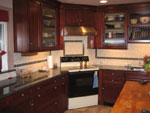 A dark stained cherry wood-mode kitchen