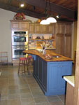A raised panel kitchen with a cottage blue island.