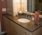 A white bathroom vanity with an undermount sink and a granite counter-top.